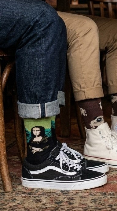 Two people sitting in a bar wearing fun colorful socks