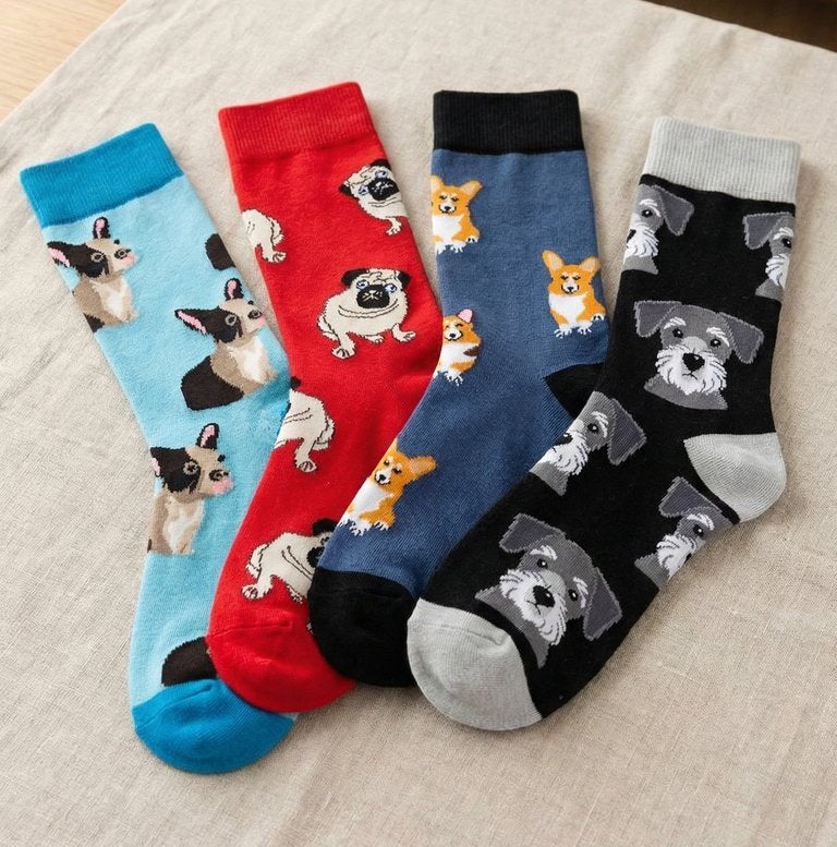 Four pairs of socks with dog patterns on a textured surface